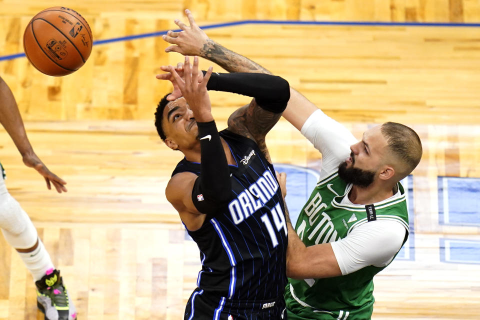 Boston Celtics guard Evan Fournier, right, knocks the ball from the hands of Orlando Magic guard Gary Harris (14) during the first half of an NBA basketball game, Wednesday, May 5, 2021, in Orlando, Fla. (AP Photo/John Raoux)