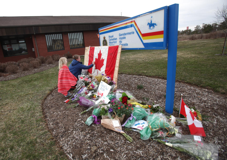 ENFIELD, NS - APRIL 20:  Children sign a Canadian flag at an impromptu memorial in front of the RCMP detachment April 20, 2020 in Enfield, Nova Scotia, Canada. It was the home detachment of slain RCMP Constable Heidi Stevenson, who was one of 19 people killed during Sunday's shooting rampage, including the gunman. The rampage, which was Canada's worst mass killing, began Saturday night in Portapique, and continued through other rural communities in the Maritime Provinces. (Photo by Tim Krochak/Getty Images)