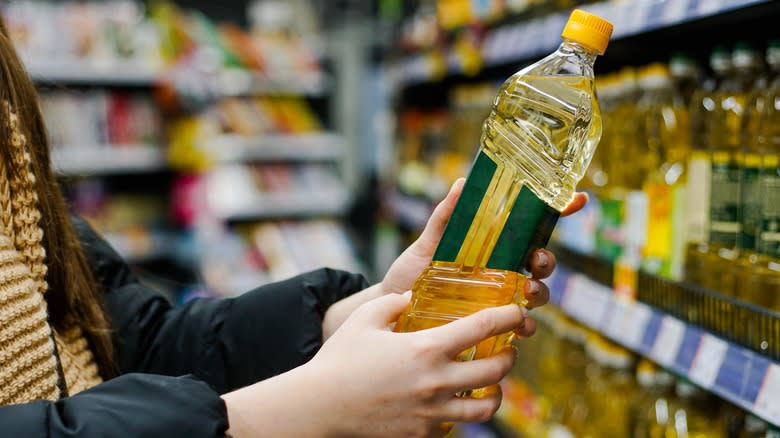 Woman holding bottle of sunflower oil