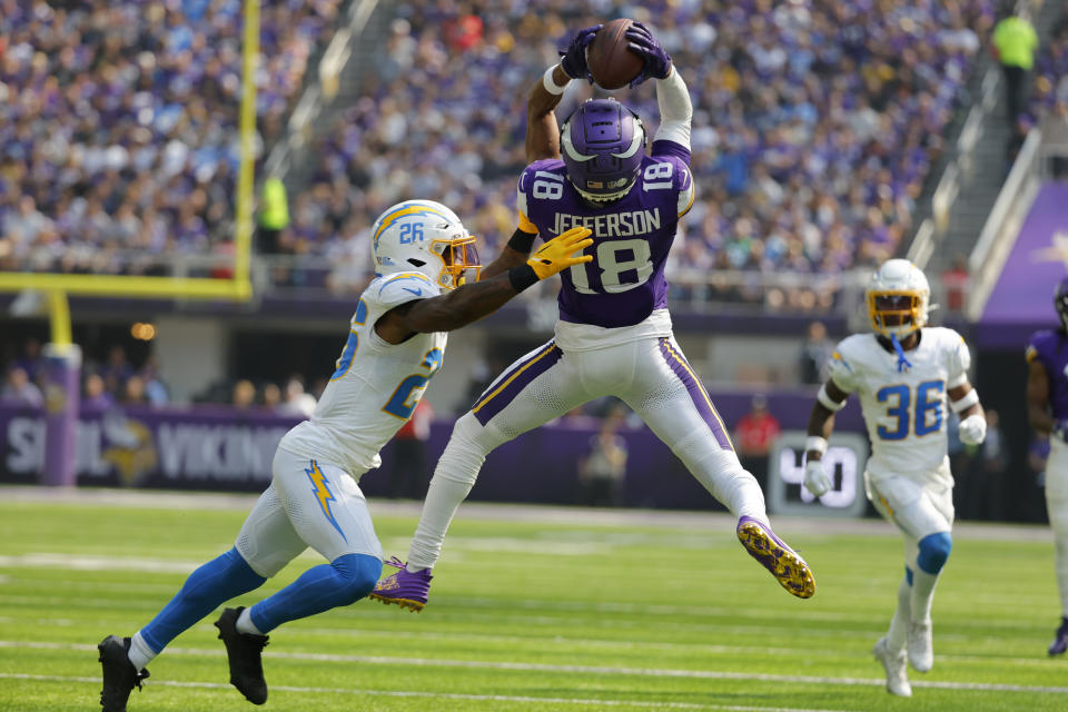 FILE - Minnesota Vikings wide receiver Justin Jefferson (18) catches a pass over Los Angeles Chargers cornerback Asante Samuel Jr. (26) during the first half of an NFL football game, Sept. 24, 2023, in Minneapolis. The Vikings designated wide receiver Jefferson for return from injured reserve Wednesday, Nov. 8, bringing the 2022 NFL Offensive Player of the Year back to practice with three weeks to assess the readiness of his strained right hamstring for game action. (AP Photo/Bruce Kluckhohn, File)