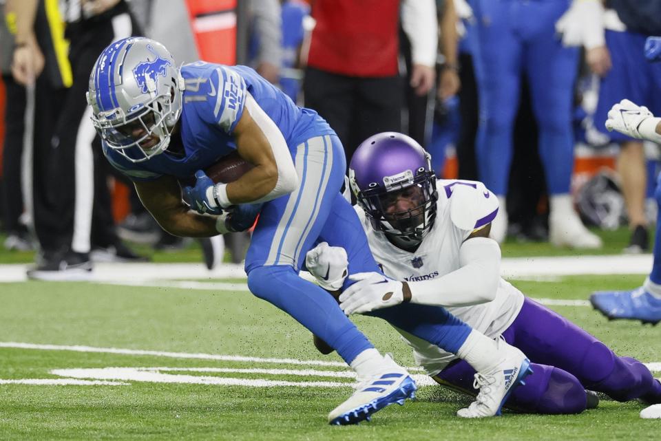 Detroit Lions' Amon-Ra St. Brown is stopped by Minnesota Vikings' Patrick Peterson during the second half of an NFL football game Sunday, Dec. 11, 2022, in Detroit. (AP Photo/Duane Burleson)