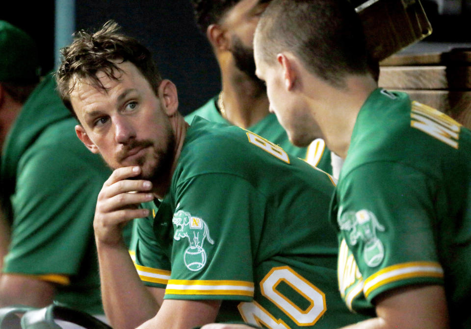 Oakland Athletics starting pitcher Chris Bassitt, left, talks with catcher Sean Murphy, right, in the dugout during the sixth inning of a baseball game against the Texas Rangers in Arlington, Texas, Sunday, July 11, 2021. (AP Photo/Ray Carlin)