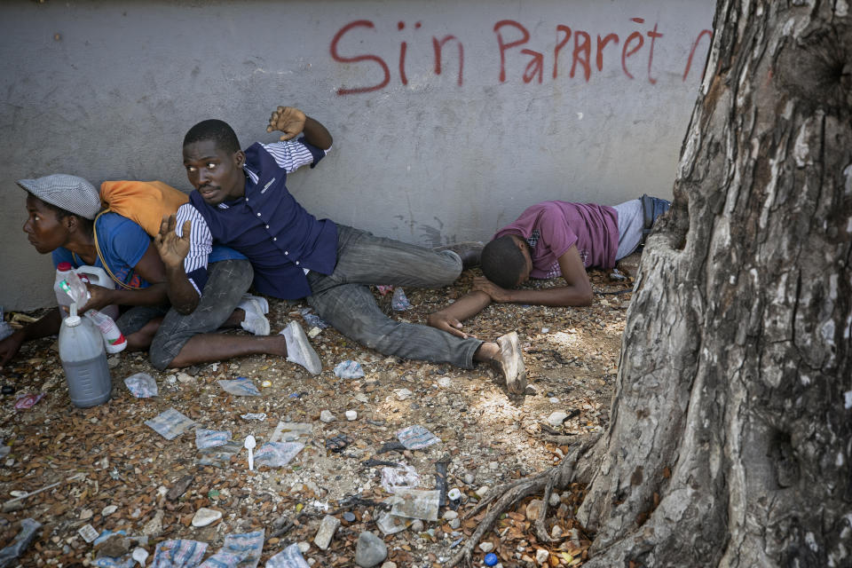 People take cover after presidential guards opened fire to disperse mourners after clashing with protesters attending a public funeral for two people killed in recent protests, in Port-au-Prince, Haiti, Oct. 16, 2019. The image was part of a series of photographs by Associated Press photographers which was named a finalist for the 2020 Pulitzer Prize for Breaking News Photography. (AP Photo/Rebecca Blackwell)