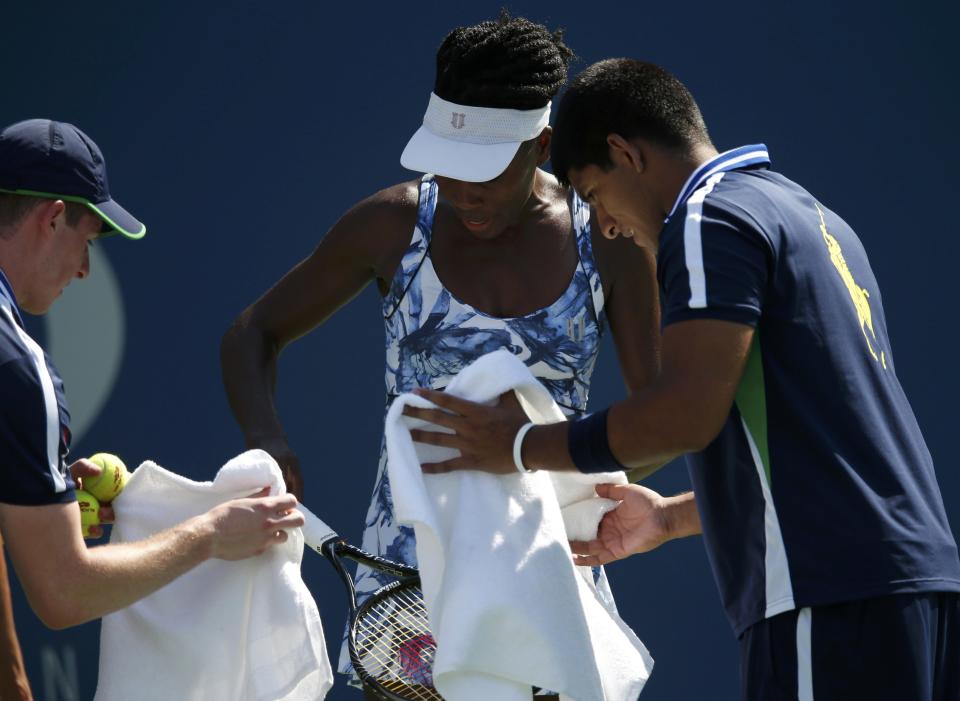 Venus Williams (C) of the U.S. and ball boys capture a bee while playing Kimiko Date-Krumm of Japan during their match at the 2014 U.S. Open tennis tournament in New York, August 25, 2014. REUTERS/Mike Segar (UNITED STATES - Tags: SPORT TENNIS)