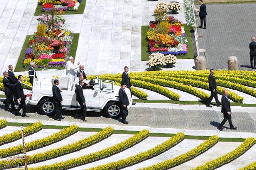 El 'papamóvil' pasa junto a las flores que decoran la Basílica de San Pedro del Vaticano con motivo del Domingo de Pascua el 20 de abril de 2014 (AFP | Andreas Solaro)