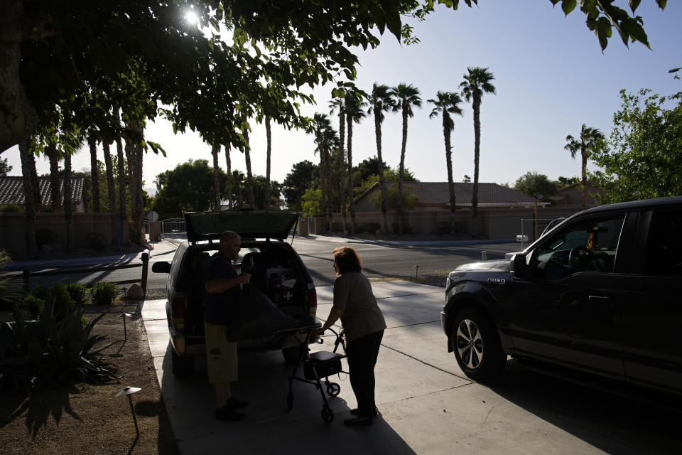 Maria Jackson, right, moves into a room at a home with the help of friend David Mcfarlan Monday, May 8, 2023, in Las Vegas. Jackson, a longtime massage therapist, lost her customers when the pandemic triggered a statewide shutdown in March 2020 and was evicted from her apartment earlier this year. (AP Photo/John Locher)