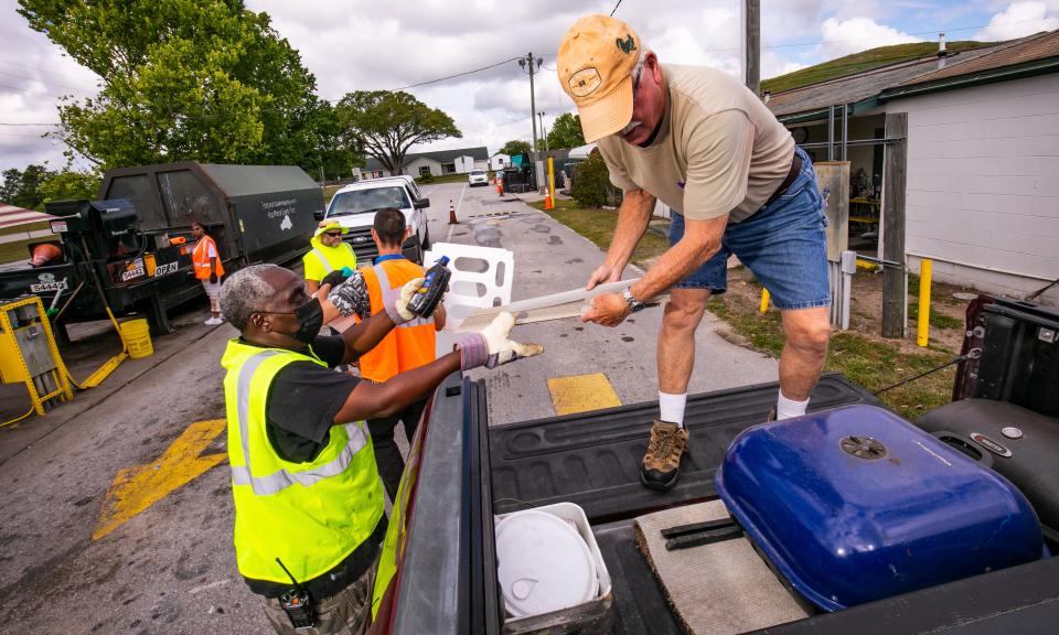 Danton Jones, right, separates items to be thrown into a trash compactor or recycled as Recycling Attendant John Timmons, left, helps him as people were dropping off household garbage and recyclables at the Baseline Recycling Center Friday morning, May 13.