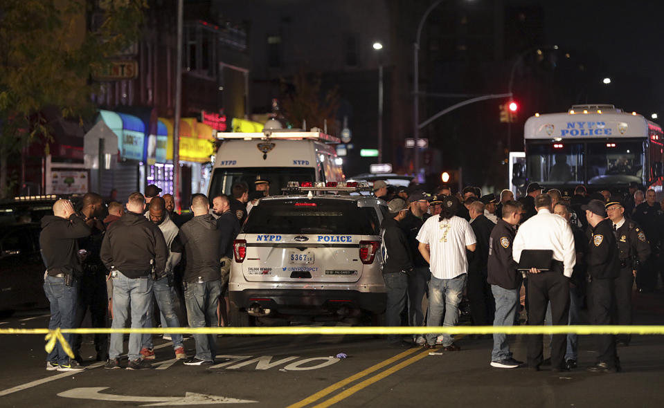 New York Police and other emergency personnel investigate the scene of a shooting where two police officers were injured and one person was shot, Friday, Oct. 25, 2019, in the Brownsville neighborhood of the Brooklyn borough of New York. (AP Photo/Julius Motal)