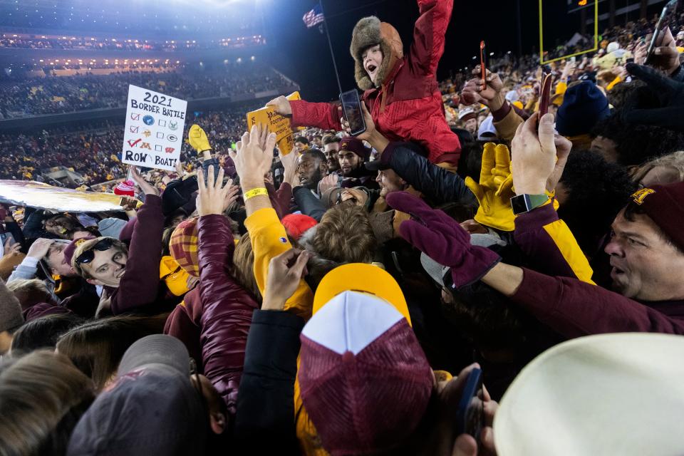 Minnesota fans storm the field to touch the Paul Bunyan's Axe after the Golden Gophers victory over Wisconsin on Saturday.