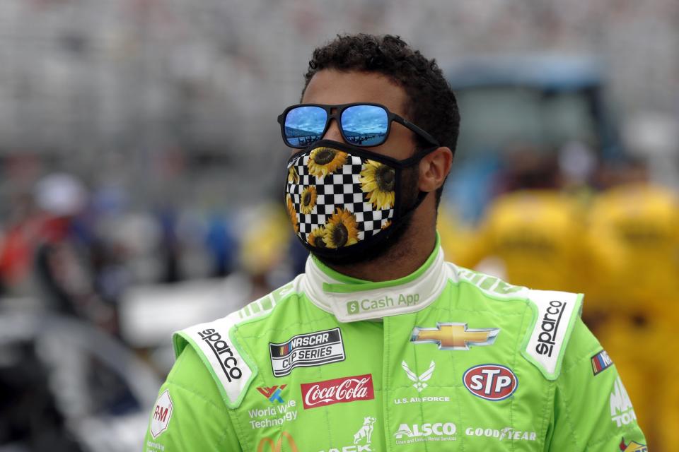 FILE - In this Sunday, Aug. 2, 2020, file photo, driver Bubba Wallace waits for the start of a NASCAR Cup Series auto race at the New Hampshire Motor Speedway in Loudon, N.H. The pandemic only accelerated the inevitable: The driver market bubble, pushed to its limit with multi-million dollar salaries for nearly two decades, is about to burst. A major reset has arrived and team owners have all the power. They can pick and choose between drivers who bring sponsorship dollars (Bubba Wallace) or drivers who have won races (Erik Jones). (AP Photo/Charles Krupa, File)