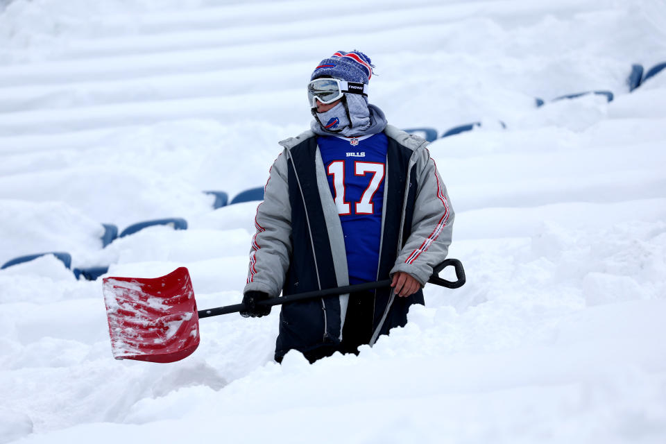 A person clears snow from the seats before the Buffalo Bills game in Orchard Park, N.Y., on Monday. (Timothy T. Ludwig/Getty Images)