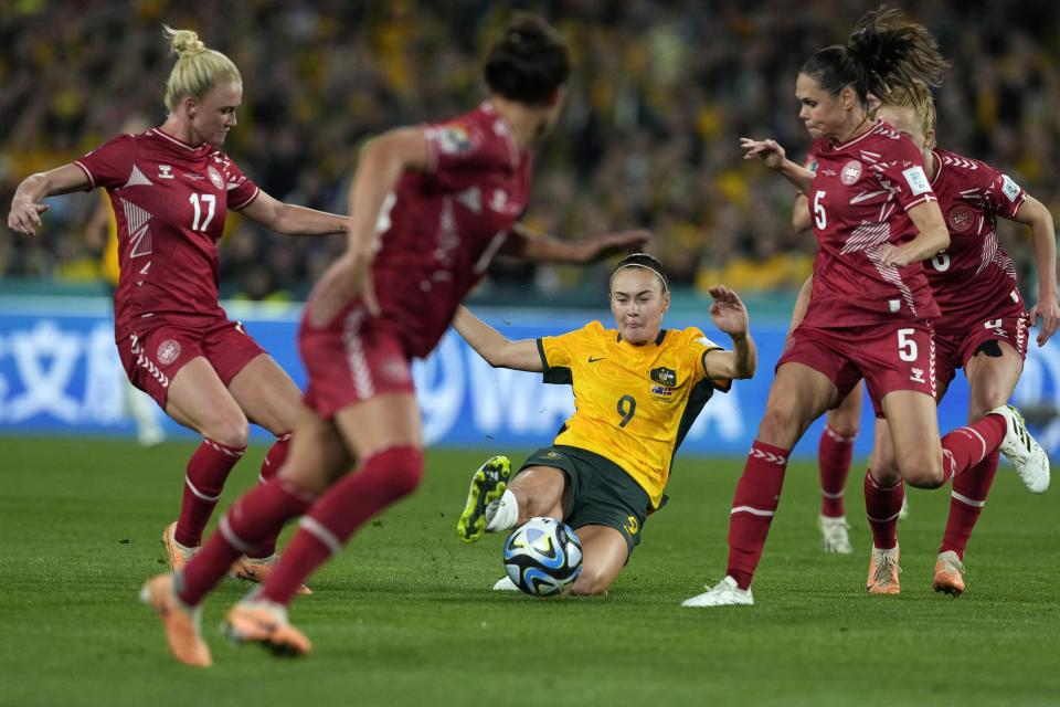 Australia's Caitlin Foord, bottom, passes the ball during the Women's World Cup round of 16 soccer match between Australia and Denmark at Stadium Australia in Sydney, Australia, Monday, Aug. 7, 2023. (AP Photo/Mark Baker)