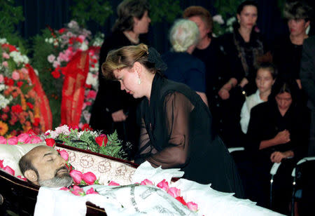 FILE PHOTO: A woman lays flowers during a funeral of Ivan Kivelidi, a prominent Russian banker and the chairman of the 'Russian Businessmen' round table organisation in Moscow, Russia August 8, 1995. REUTERS/Alexander Natruskin/File Photo