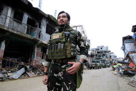 Captain Arnel Carandang of the Philippine army 1st scout ranger battalion past damaged houses and building in Sultan Omar Dianalan boulevard at Mapandi district in Marawi city, southern Philippines September 13, 2017. REUTERS/Romeo Ranoco