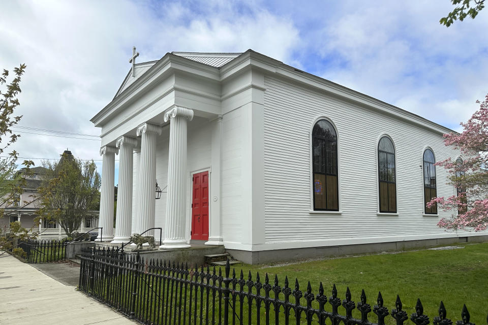 The now-closed St. Mark's Episcopal church, rests near grass and an iron fence, Monday, May 1, 2023, in Warren, R.I. A nearly 150-year-old stained-glass window from the Rhode Island church that depicts Christ and three New Testament women with dark skin has stirred up questions about race and the place of women in both biblical and 19th century society. (AP Photo/Mark Pratt)