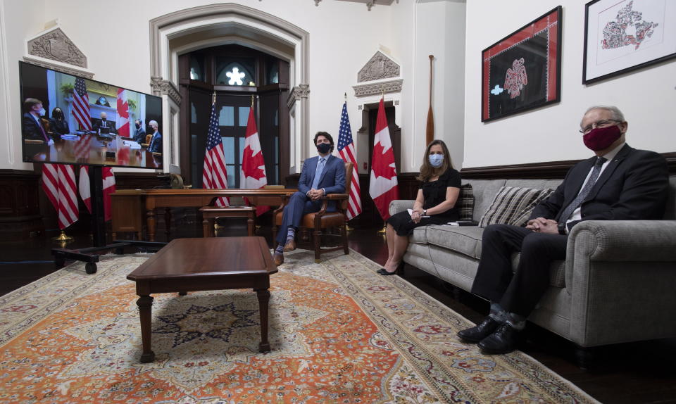 Canadian Prime Minister Justin Trudeau is seen with Deputy Prime Minister and Minister of Finance Chrystia Freeland and Foreign Affairs Minister Marc Garneau as they meet virtually with United States President Joe Biden from his office on Parliament Hill in Ottawa, Ontario, Tuesday, Feb. 23, 2021. (Adrian Wyld/The Canadian Press via AP)