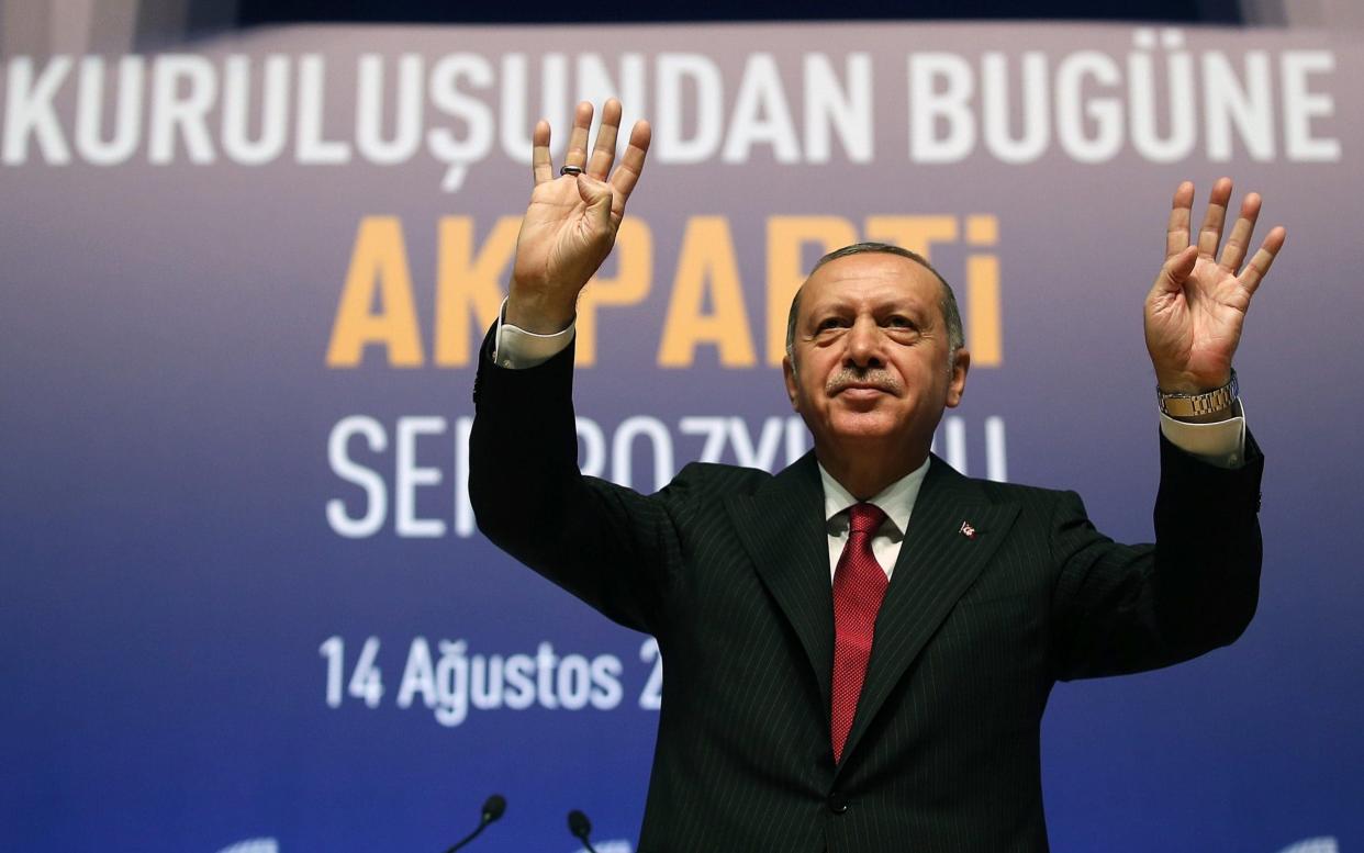 Recep Tayyip Erdogan gestures while addressing at a symposium at the ATO Congresium Hall in Ankara - Anadolu