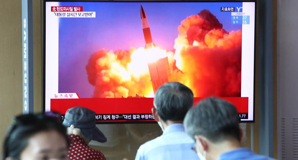 People watch a TV showing a file image of a North Korean missile launch at the Seoul Railway Station on Wednesday