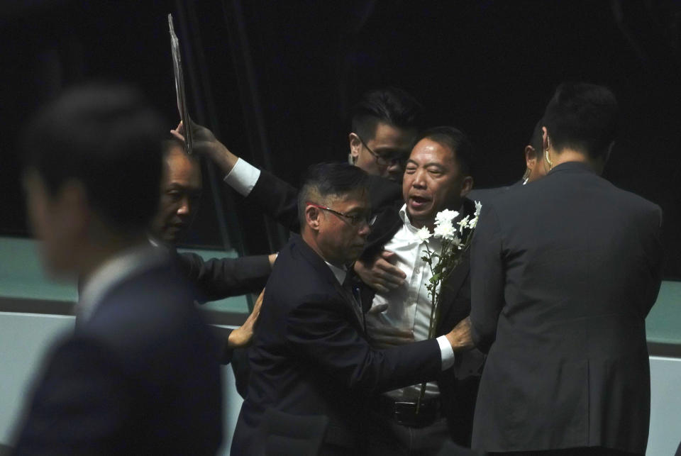 A pro-democracy lawmaker, center, is taken away as he shouts a slogan while Hong Kong Chief Executive Carrie Lam arrives at chamber of the Legislative Council in Hong Kong, on Thursday, Oct. 17, 2019. (AP Photo/Vincent Yu)