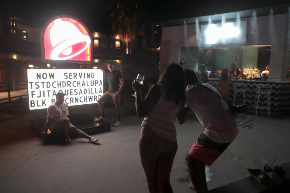 Guests take photos at Taco Bell's 'The Bell' hotel in Palm Springs, Calif. on Thursday, August 8, 2019.