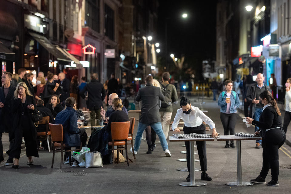 Staff pack seating outside bars in Soho, London the day after pubs and restaurants were subject to a 10pm curfew to combat the rise in coronavirus cases in England. (Photo by Dominic Lipinski/PA Images via Getty Images)