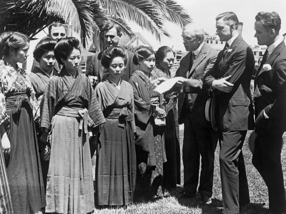 Japanese picture brides having their passports investigated by members of Congress in 1920.