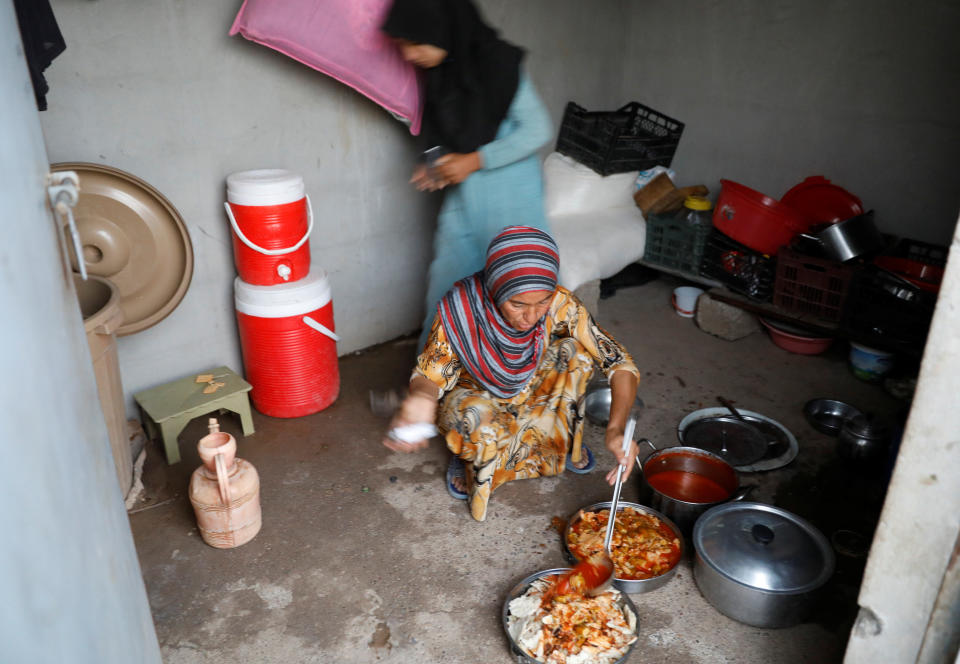 A displaced Iraqi woman from Mosul prepares food for her family's Iftar at a refugee camp at al-Khazir in the outskirts of Erbil, Iraq June 10.