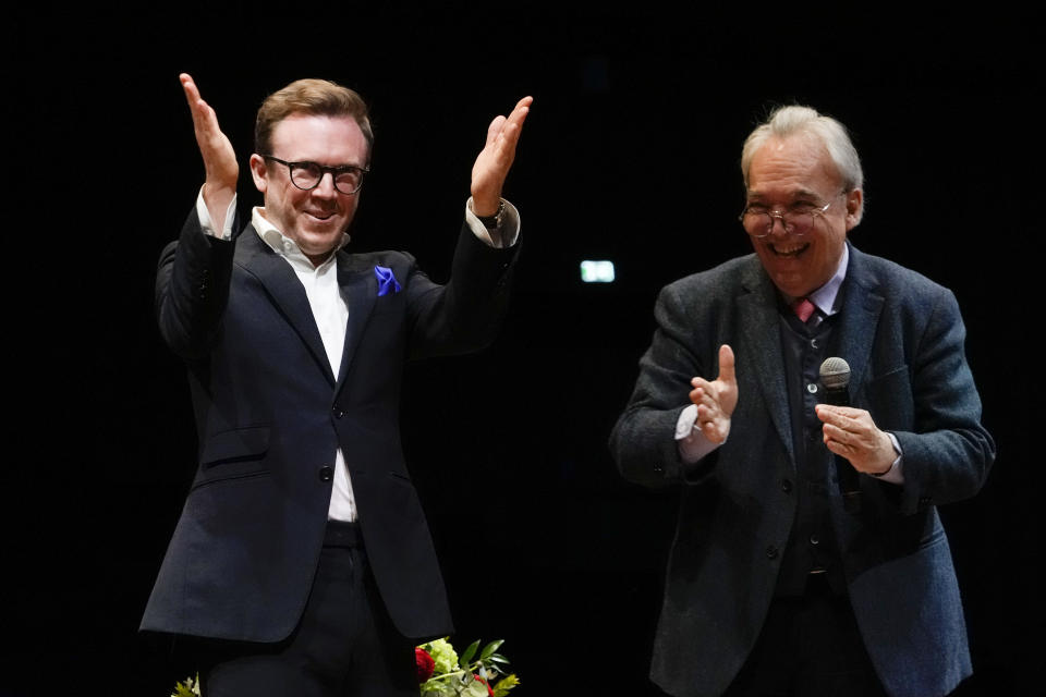 Maestro Daniel Harding, the new music director of Rome's Santa Cecilia orchestra, left, acknowledges the applause as he arrives at a press conference on the occasion of his presentation to media in Rome, Monday, March 6, 2023. (AP Photo/Gregorio Borgia)