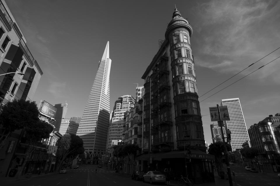 Late light falls on Francis Ford Coppola's Sentinel Building, right, and the Transamerica Pyramid in San Francisco on May 7, 2020. Normally, the months leading into summer bring bustling crowds to the city's famous landmarks, but this year, because of the coronavirus threat they sit empty and quiet. Some parts are like eerie ghost towns or stark scenes from a science fiction movie. (AP Photo/Eric Risberg)