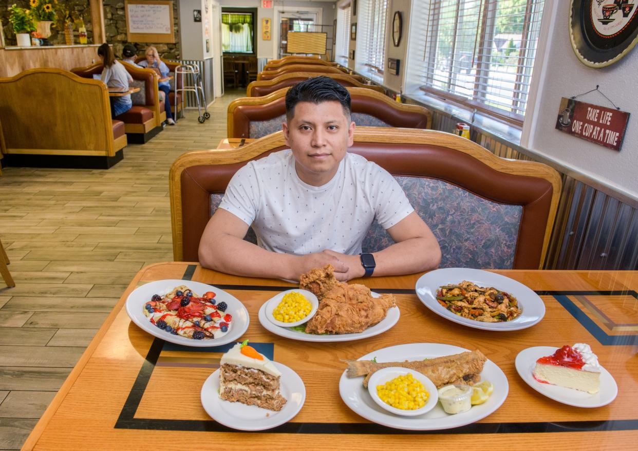 Managing partner Oscar Ixba displays a few of the "all-American, home-cooked" meals available at The 520 Cafe at 520 Bloomington Road in East Peoria. Once the site of Mel's Cafe, the new owners have completely remodeled the business and revamped the menu.