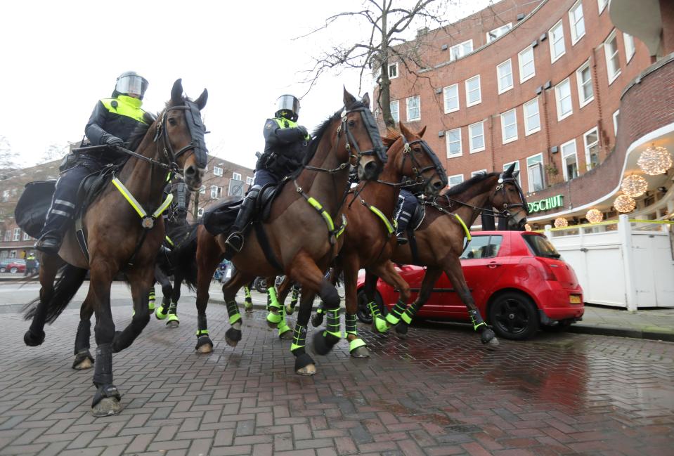 Police officers ride horses during a protest against restrictions in AmsterdamREUTERS