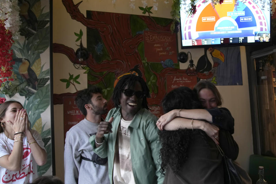 FILE - People react to the projection of results during the second round of the legislative elections, near Republique Plaza in Paris, on July 7, 2024. For many French voters of diverse backgrounds, last Sunday’s parliamentary election results were a relief, seemingly an embrace of the country’s ethnic heterogeneity instead of a victory for xenophobic far-right forces. (AP Photo/Christophe Ena, File)