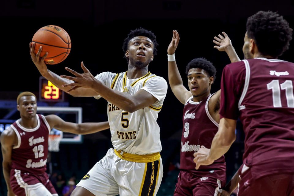 Grambling State guard Tra'Michael Moton (5) shoots as Texas Southern guards Jordan Gilliam (11) and PJ Henry (3) defend during the first half of an NCAA college basketball game in the championship of the Southwestern Athletic Conference Tournament, Saturday, March 11, 2023, in Birmingham, Ala. (AP Photo/Butch Dill)