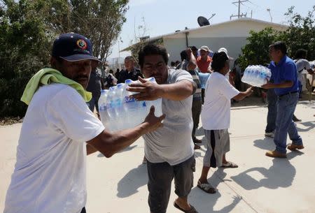 Residents carry bottles of water in a school used as a shelter in Cabo San Lucas, after Hurricane Odile hit in Baja California September 18, 2014. REUTERS/Henry Romero