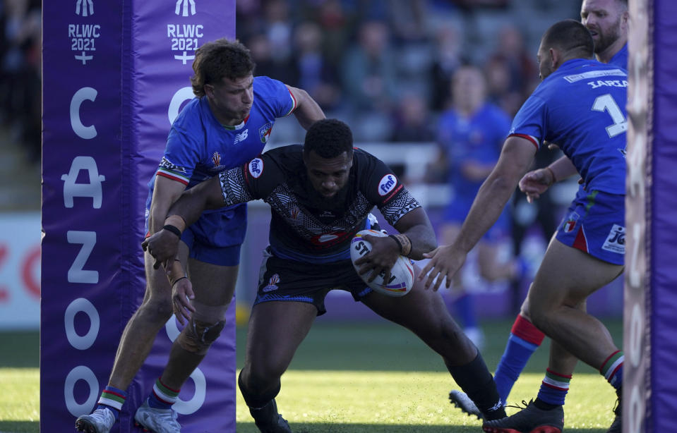 Fiji's Ben Nakubuwai evades a tackle from Italy's Luke Polselli as he goes over to score a try during the Rugby League World Cup group B match at Kingston Park, Newcastle upon Tyne, England, Saturday Oct. 22, 2022. (Owen Humphreys/PA via AP)