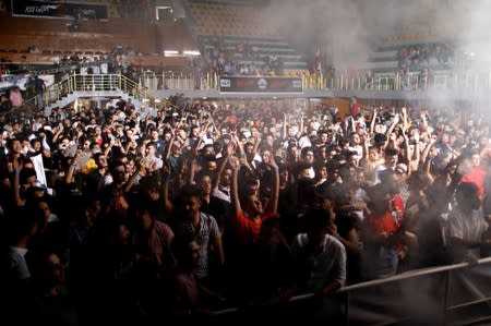 Young people dance and cheer as they attend electronic music concert with western tunes at closed Hall in Shaab Stadium for the first time in Baghdad