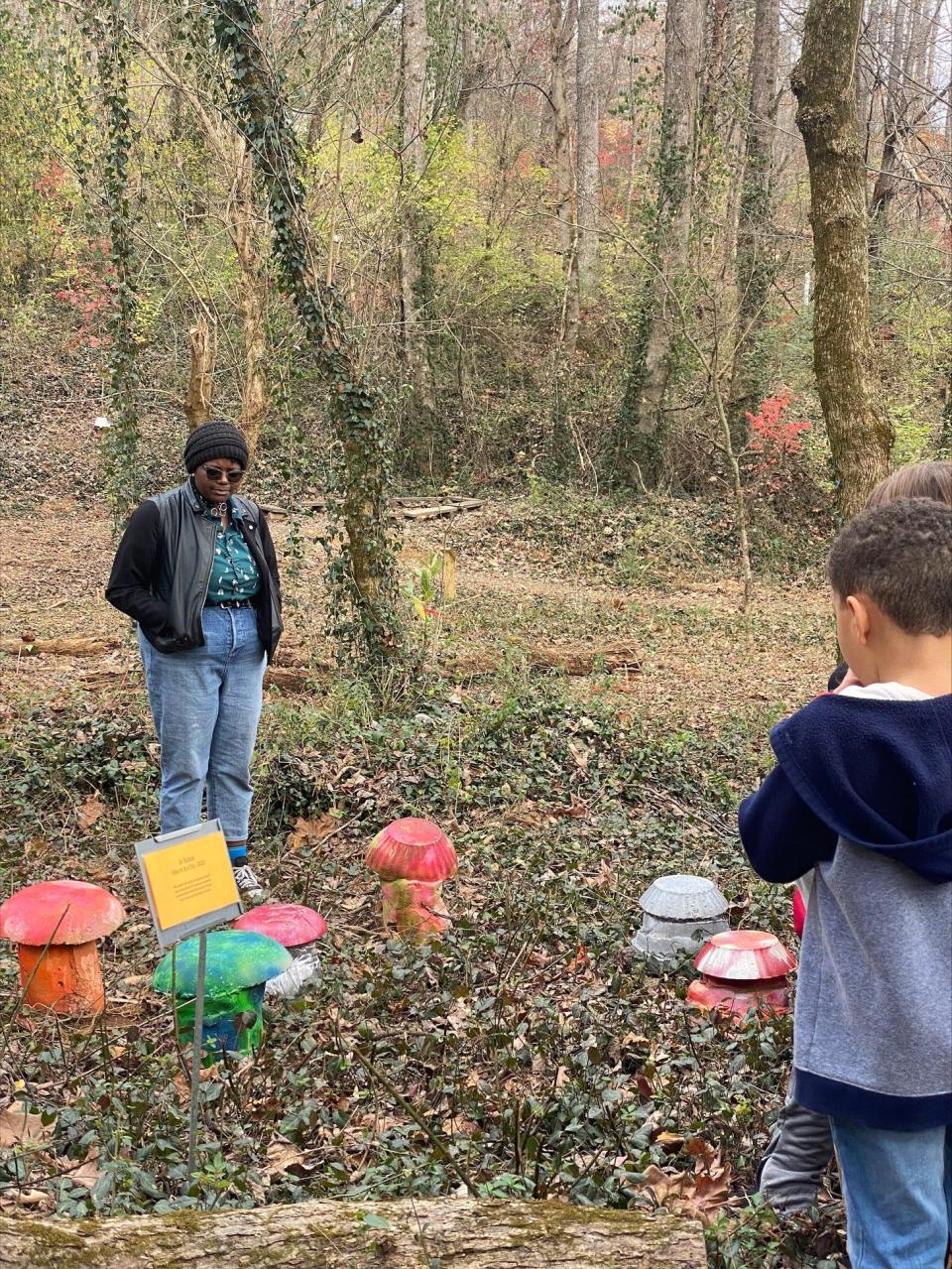 UT student Jo Sutton talks to Dogwood Elementary students as they explore her "Nature is a Trip" installation on the Dogwood Community Trail, Nov. 28, 2022.