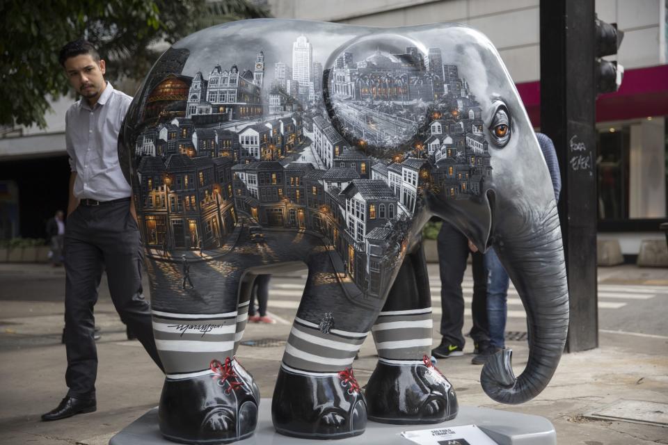 <p>A passer-by looks on an elephant sculpture as part of the 'Elephant Parade' at the Paulista Avenue in Sao Paulo, Brazil, 01 August 2017. Aug. 1, 2017. (Photo: Sebastiao Moreira/EPA/REX/Shutterstock) </p>