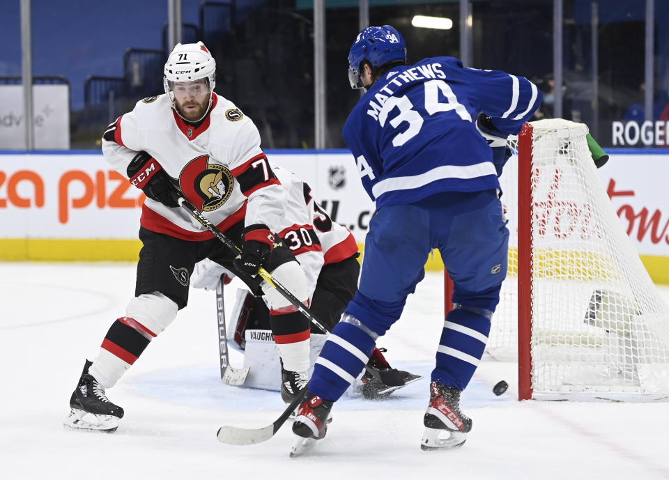 Toronto Maple Leafs center Auston Matthews (34) watches as the puck gets pass Ottawa Senators goaltender Matt Murray (30) on a shot by Maple Leafs center Joe Thornton, not shown, as Ottawa Senators center Chris Tierney (71) defends during the first period of an NHL hockey game, Thursday, Feb. 18, 2021 in Toronto. (Nathan Denette/The Canadian Press via AP)