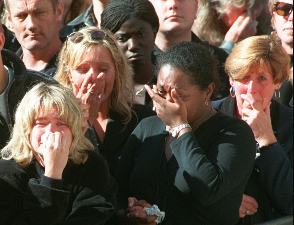 FILE - Spectators weep in the crowd along London's Whitehall Saturday Sept. 6, 1997, during funeral ceremonies for Diana, Princess of Wales. Above all, there was shock. That’s the word people use over and over again when they remember Princess Diana’s death in a Paris car crash 25 years ago this week. The woman the world watched grow from a shy teenage nursery school teacher into a glamorous celebrity who comforted AIDS patients and campaigned for landmine removal couldn’t be dead at the age of 36, could she? (AP Photo/Jerome Delay/Pool, File)