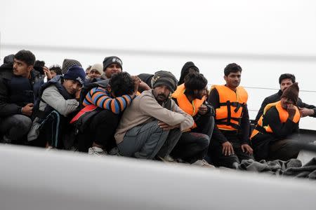 Refugees and migrants wait to disembark a Greek Coast Guard vessel at the port of Mytilene on the Greek island of Lesbos, following a rescue operation at open sea, March 22, 2016. REUTERS/Alkis Konstantinidis