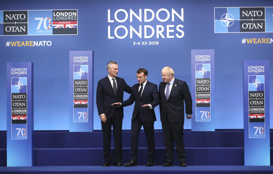 NATO Secretary General Jens Stoltenberg, left, and British Prime Minister Boris Johnson, right, welcome French President Emmanuel Macron at official arrivals for a NATO leaders meeting at The Grove hotel and resort in Watford, Hertfordshire, England, Wednesday, Dec. 4, 2019. NATO Secretary-General Jens Stoltenberg rejected Wednesday French criticism that the military alliance is suffering from brain death, and insisted that the organization is adapting to modern challenges. (AP Photo/Francisco Seco)