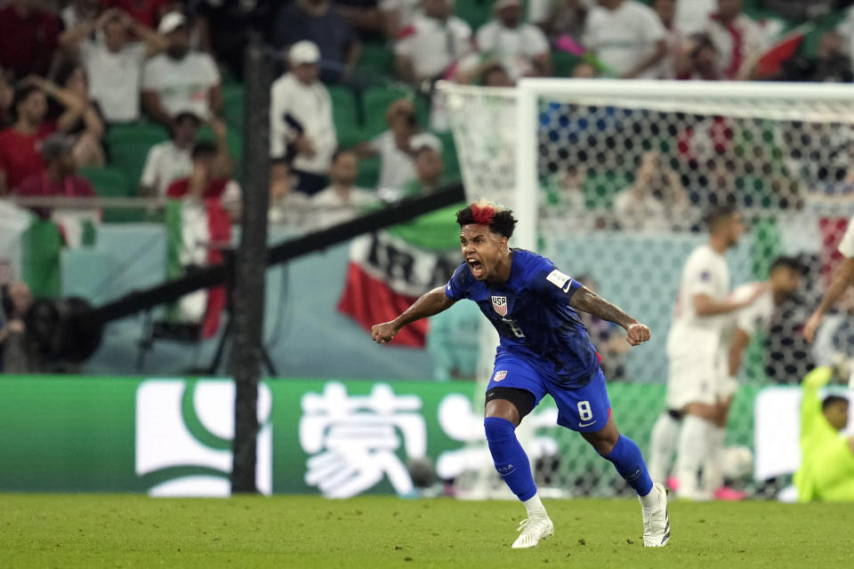 United States' Weston McKennie (8) celebrates after teammate Christian Pulisic scoring a goal during the World Cup group B soccer match between Iran and the United States at the Al Thumama Stadium in Doha, Qatar, Tuesday, Nov. 29, 2022. (AP Photo/Ashley Landis)