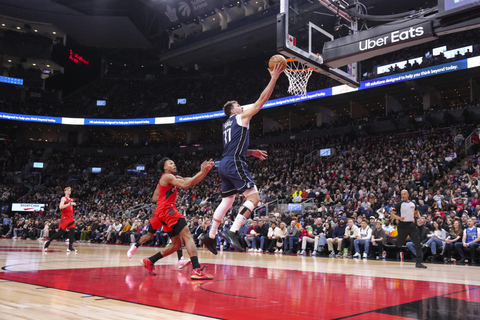 Dallas Mavericks' Luka Doncic scores past Toronto Raptors' Scottie Barnes during the second half of an NBA basketball game in Toronto on Wednesday, Feb. 28, 2024. (Chris Young/The Canadian Press via AP)