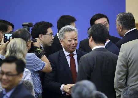 Jin Liqun (C), current secretary general of the Multilateral Interim Secretariat of Asian Infrastructure Investment Bank (AIIB), chats with delegates ahead of a signing ceremony of articles of agreement of the Asian Infrastructure Investment Bank (AIIB), at the Great Hall of the People in Beijing, June 29, 2015. REUTERS/Jason Lee