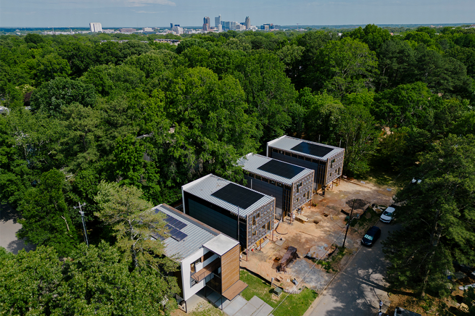 An aerial view of Tower Raleigh, a collection of three modern, net-zero-energy (NZE) homes, currently under construction at 920 Tower Street, near the Village District and Jaycee Park.