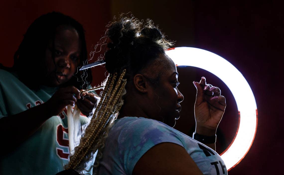 Allene Gethers ties braids into Karneisha Gamble’s hair at Shuga Braids on Decker Boulevard in Columbia. The new shop has been open since May.