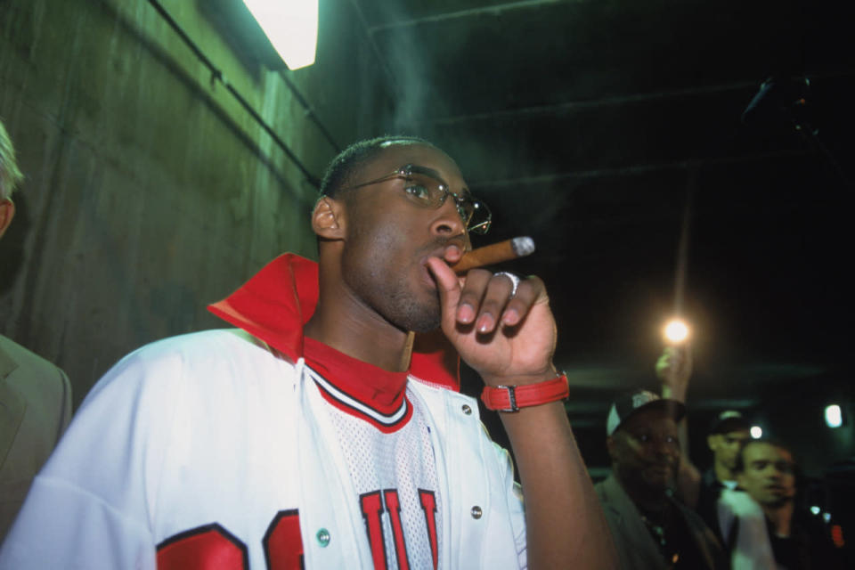 Kobe smokes a celebratory cigar after winning Game 4 of the 2002 NBA Finals, in a jersey other than his own — Michael Jordan’s Chicago Bulls  No. 23 jersey. Respect. (Photo: Getty Images)