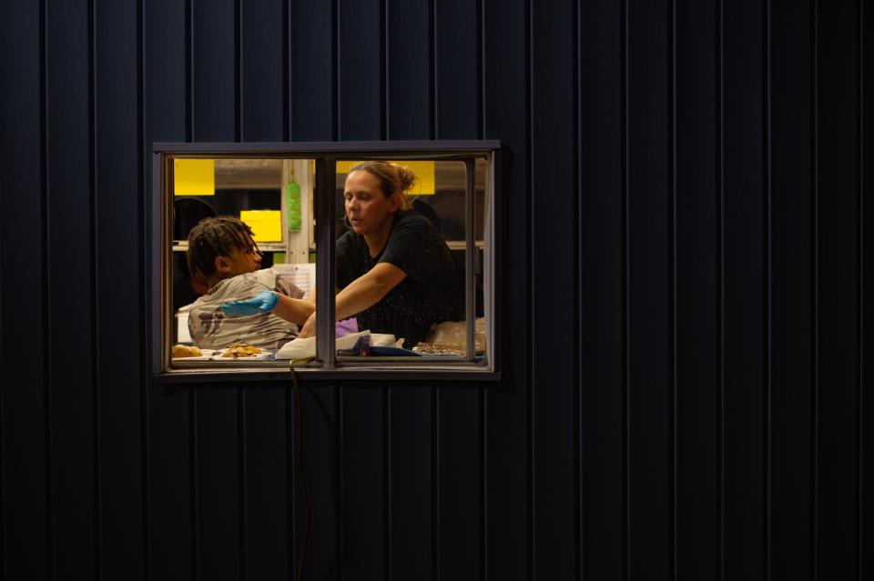 Kristina Brock works the kitchen at a booth raising money for the American Cancer Society during Tri-Fest in Henderson, Ky., Friday night, April 14, 2023.