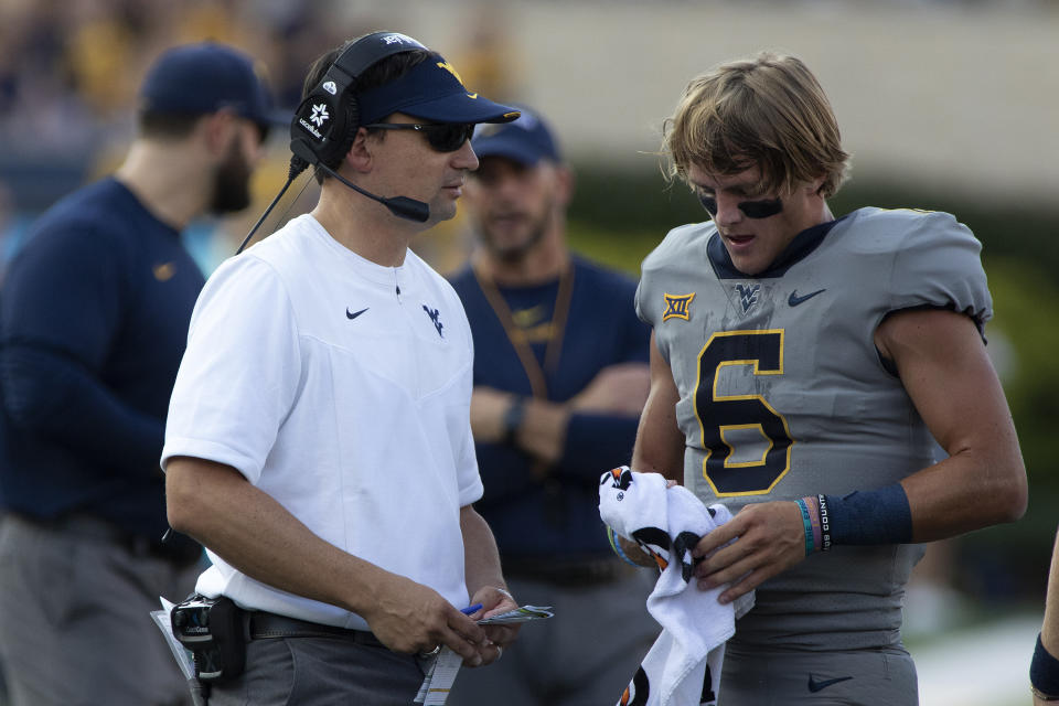 West Virginia coach Neal Brown, left, speaks with quarterback Garrett Greene (6) during the first half of an NCAA college football game against Long Island in Morgantown, W.Va., Saturday, Sept., 11, 2021. (AP Photo/Kathleen Batten)